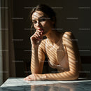 Woman in Contemplative Pose with Dramatic Shadow Patterns