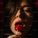 Sensual Brunette Enjoying Red Lollipop in Dramatic Light