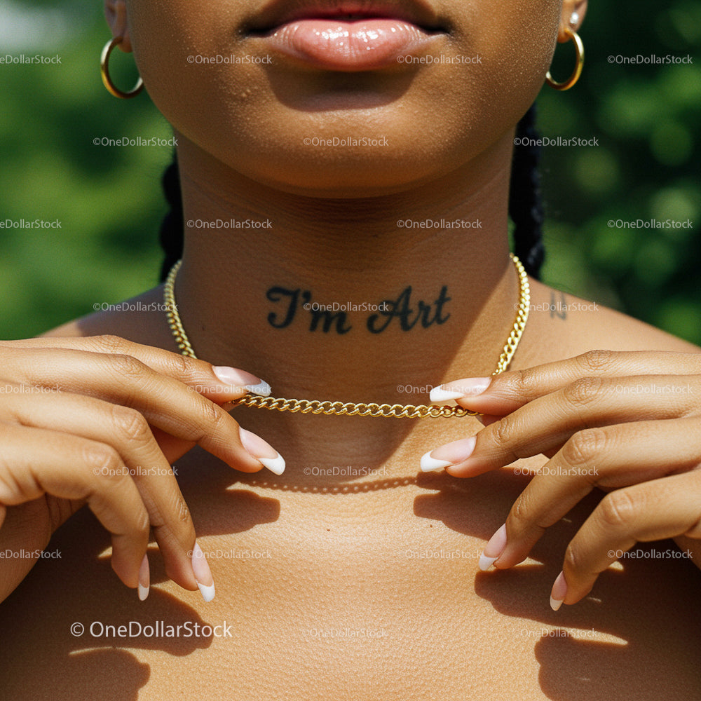 Elegant Gold Necklace and Tattoo on Sunlit Skin