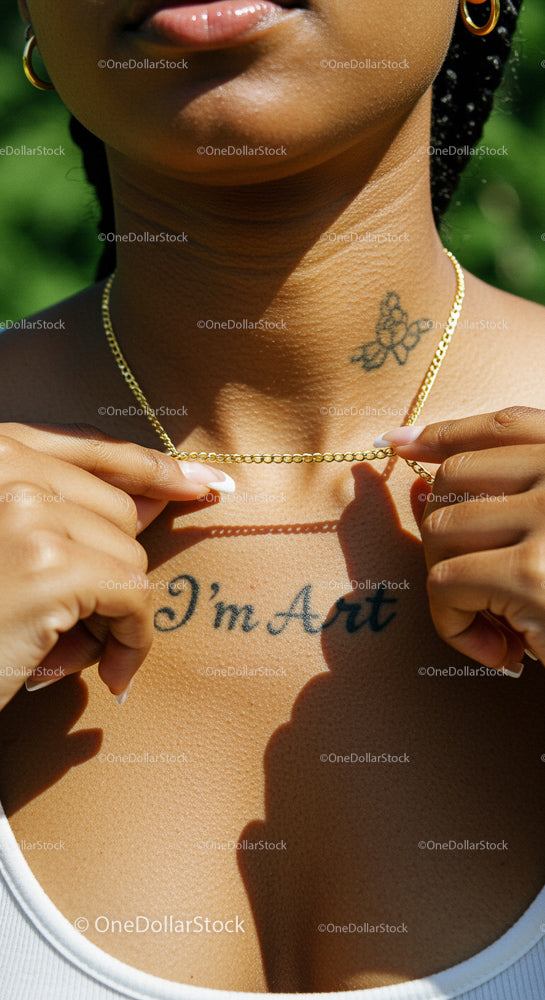 Close-Up of Gold Necklace and Artistic Tattoo