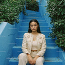 Elegant Woman Sitting on Blue Stairs with Green Foliage