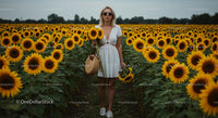 Woman in White Dress Among Vibrant Sunflowers