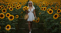 Woman in White Dress Walking Through Sunflower Field