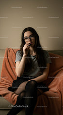 Thoughtful Woman in Glasses and Casual Attire on Sofa