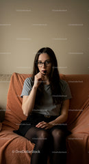 Young Woman in Glasses Contemplating on Cozy Couch