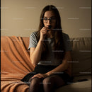 Thoughtful Young Woman with Glasses in Cozy Living Room