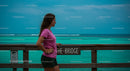 Woman in Pink Shirt on Ocean Bridge