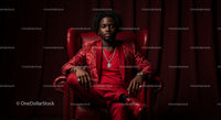 Man in Red Suit Sitting Confidently in Elegant Armchair