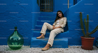 Stylish Woman in Embroidered Outfit on Blue Steps
