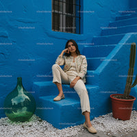 Young Woman Relaxing on Vibrant Blue Stairs with Cactus
