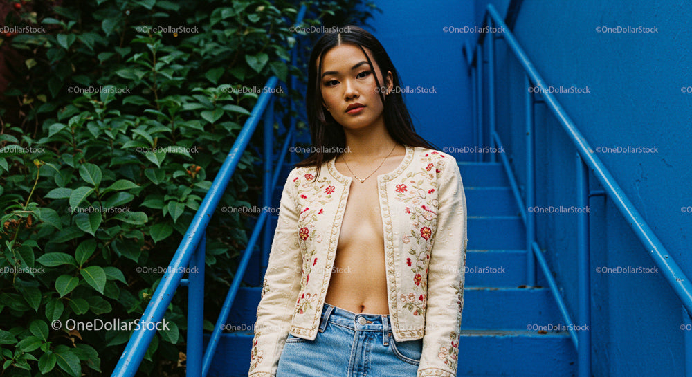 Stylish Woman in Embroidered Jacket on Blue Urban Stairs