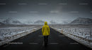 Person in Yellow Jacket Facing Snowy Mountain Road