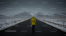 Traveler in Yellow Jacket on Snowy Mountain Road