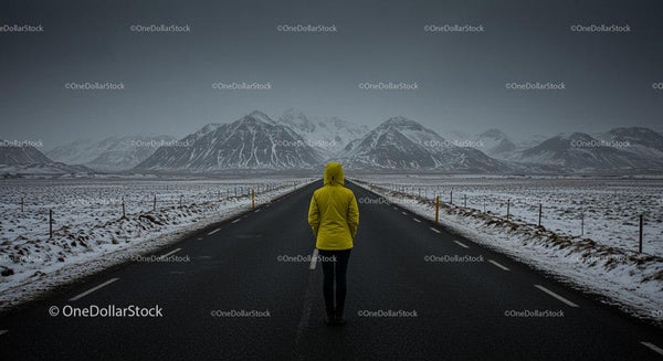 Traveler in Yellow Jacket on Snowy Mountain Road