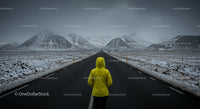 Person in Yellow Jacket Facing Snowy Mountain Road