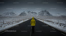 Traveler in Yellow Jacket on Snowy Mountain Road