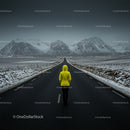 Lone Traveler on Snowy Road with Majestic Mountain View
