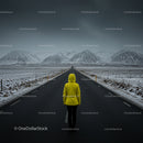 Person in Yellow Jacket on Snowy Mountain Road