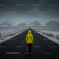 Person in Yellow Jacket on Snowy Mountain Road