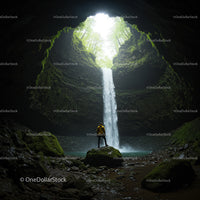 Adventurer Exploring Lush Waterfall Cave
