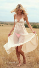 Blonde Woman in Flowy Summer Dress Strolling in Sunlit Field