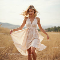 Blonde Woman in Flowing Beige Summer Dress in Countryside