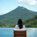 Woman Relaxing by Infinity Pool with Mountain View