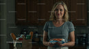 Smiling Woman in Modern Kitchen Holding Grocery Items