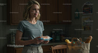 Smiling Woman Unpacking Groceries in a Cozy Kitchen