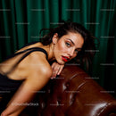 Elegant Woman Reclining on a Leather Sofa in Luxurious Setting
