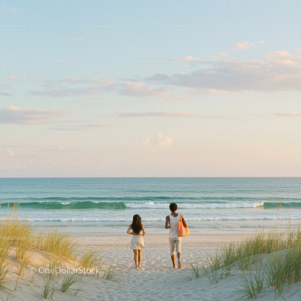 Two People Strolling on a Sandy Beach at Sunset