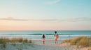 Couple Enjoying a Romantic Sunset Walk on Sandy Beach