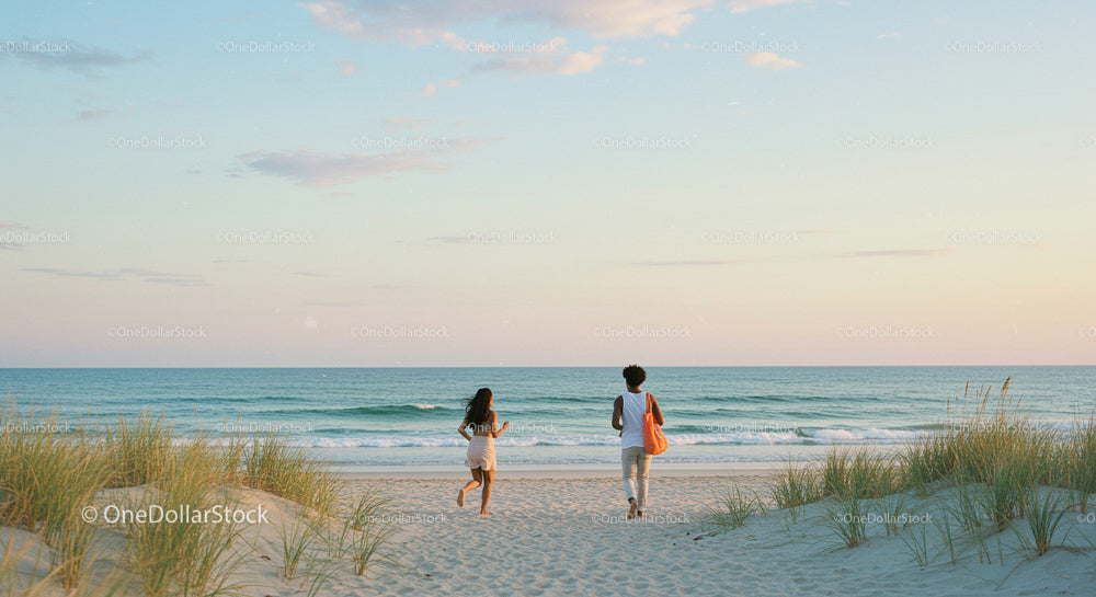 Two People Walking Towards Ocean at Tranquil Beach Sunset
