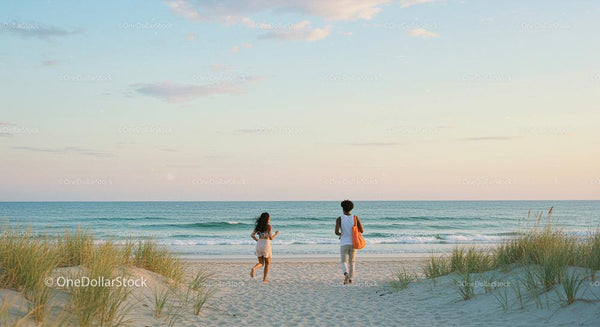 Two People Walking Towards Ocean at Tranquil Beach Sunset