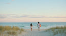 Couple Walking Along Serene Beach at Sunset