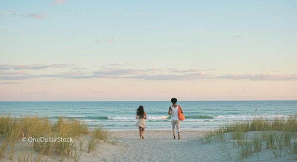 Couple Walking Along Serene Beach at Sunset