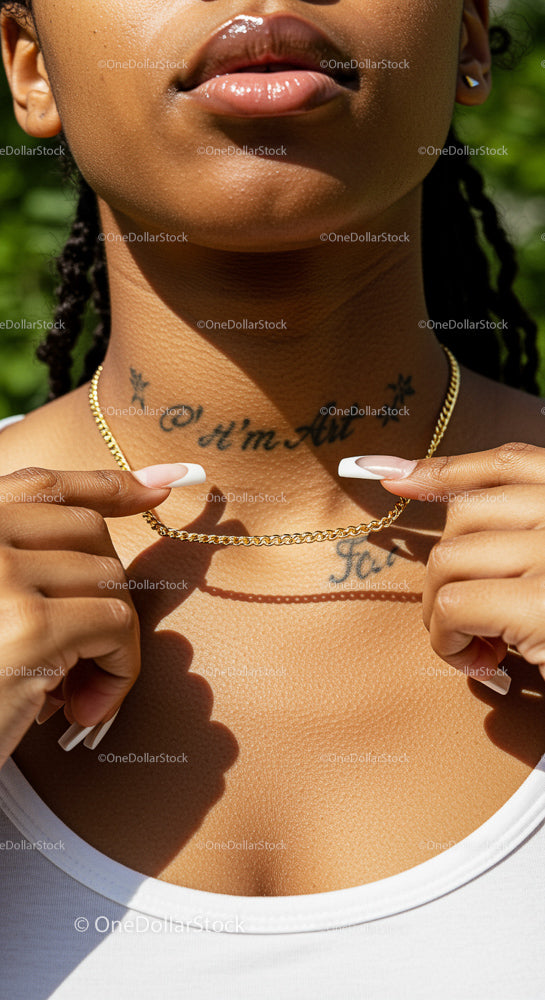 Woman Showcasing Gold Chain Necklace with Tattoos