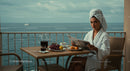 Woman Reading Newspaper on Seaside Balcony with Breakfast