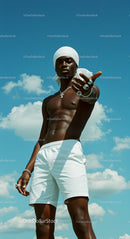 Confident Man in White Shorts Under Blue Sky