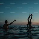 Silhouetted Figures Playing in Ocean at Sunset