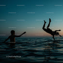 Silhouetted Boys Playing in Ocean at Sunset