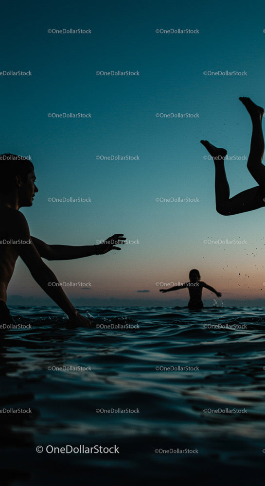 Silhouetted Friends Playing in the Ocean at Sunset