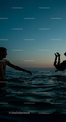 Silhouettes Enjoying a Playful Swim at Sunset
