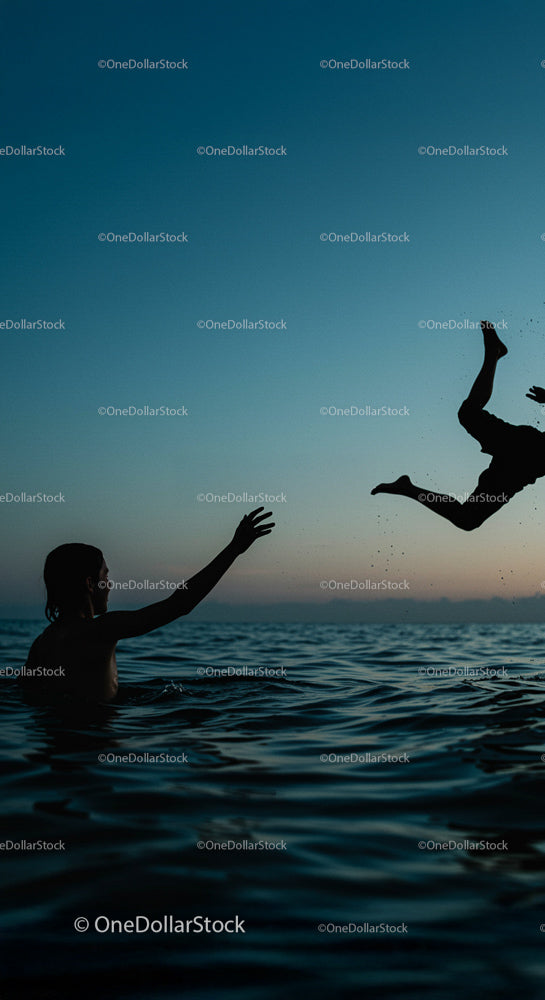 Silhouette of People Splashing in the Ocean at Sunset