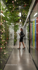 Businesswoman Walking Through Modern Office with Vertical Garden