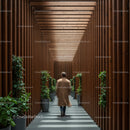 Man Walking Through Modern Wooden Corridor with Green Plants