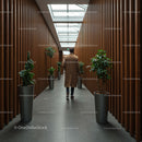 Man Walking in Modern Corridor with Indoor Plants