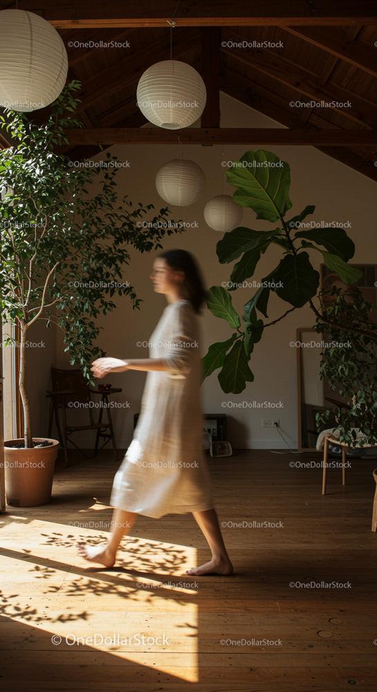 Woman in Motion in Sunlit Room with Indoor Plants