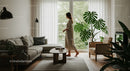 Minimalist Living Room with Houseplants and Walking Woman