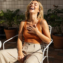 Joyful Woman Laughing on a Sunny Patio with Green Plants
